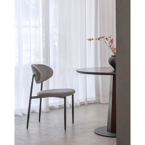 Designstol med svarta metallben och grått stoppad sits