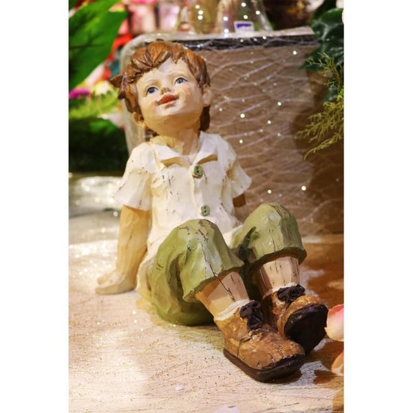 Dekorativ figurin pojke i gröna byxor 26 cm polyresin