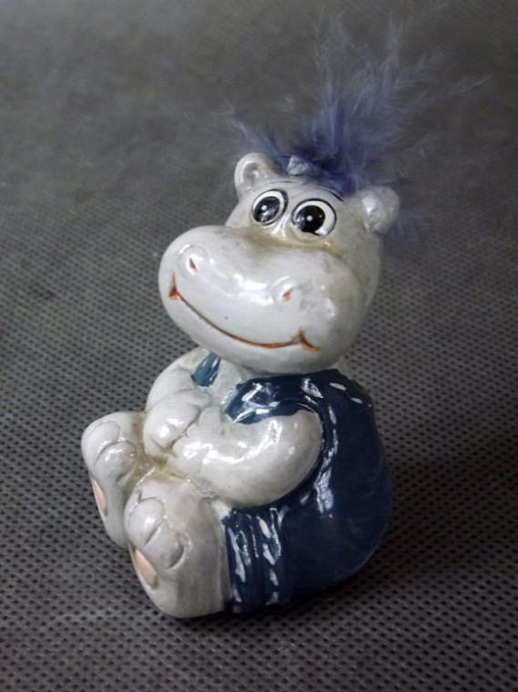 Keramisk figur sittande flodhäst med fjäderhår 8x4 cm
