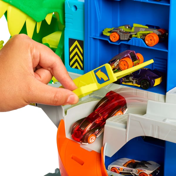 Hot Wheels City Det ultimata T-Rex-garaget med 2 leksaksbilar och förvaring av över 50 bilar, tävla och utför stunttrick, dinosauriefiende