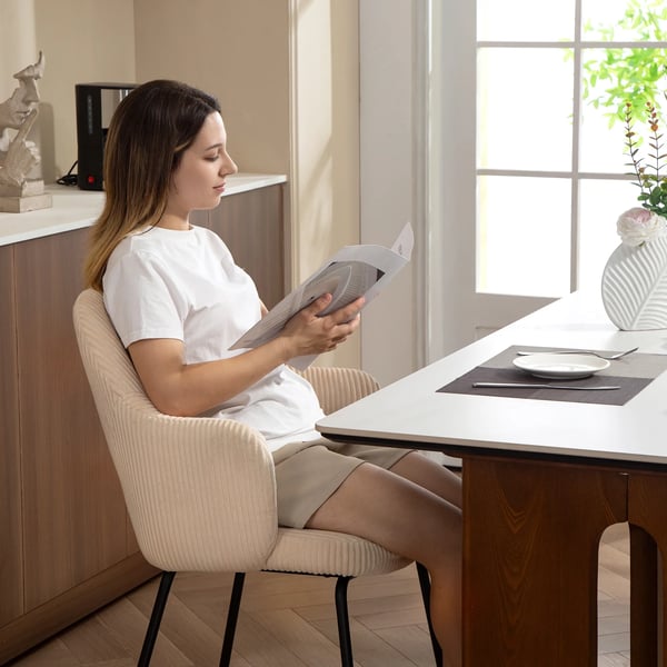 spisestol i beige kord med stålben, skålformet design og gulvbeskyttere