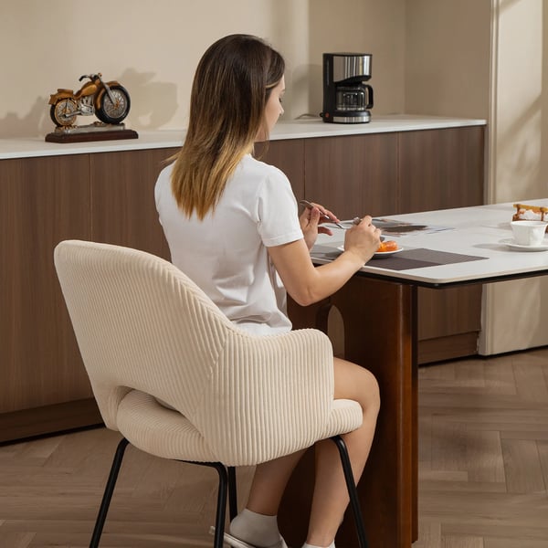 spisestol i beige kord med stålben, skålformet design og gulvbeskyttere