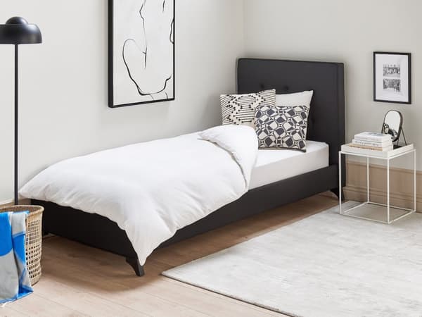 En sort polstret seng 90 x 200 cm med en ramme og en sengegavl med dekorative knapper
