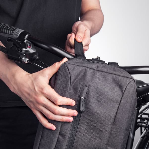Grå cykeltaske til tablet fastgjort til styret med en skulderrem