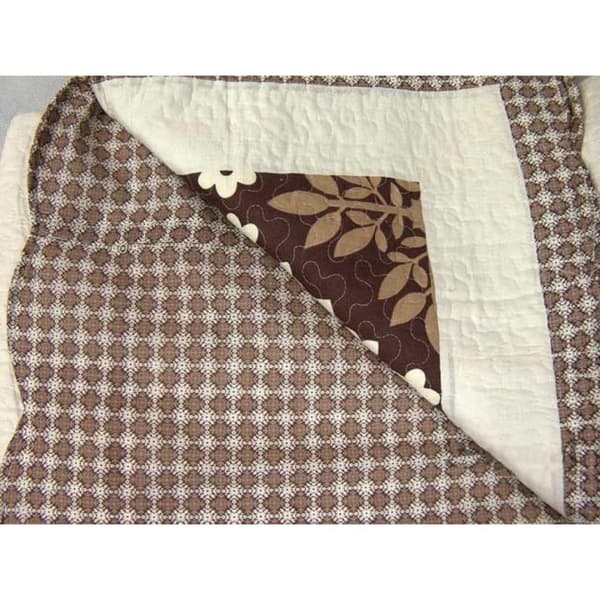 Sarja kermanvärisiä ja ruskeita patchwork päiväpeitettä ja käännettyjä puuvillaisia tyynyliinoja