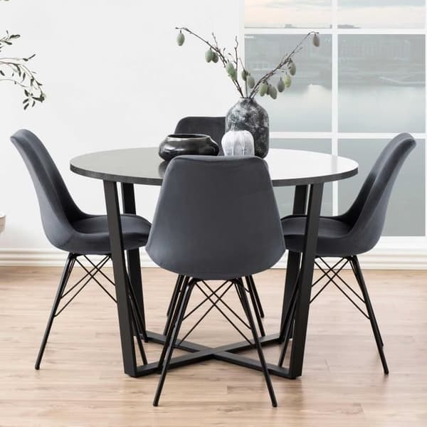 Stolen coquille Irma är klädd i mörkgrå sammet och har ben i svart pulverlackad metall. Denna stol