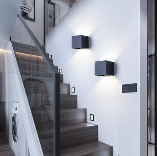 Modern fyrkantig vägglampa i aluminium med kabelansluten upp- och nedåtriktad belysning, lämplig för rum och trappor.