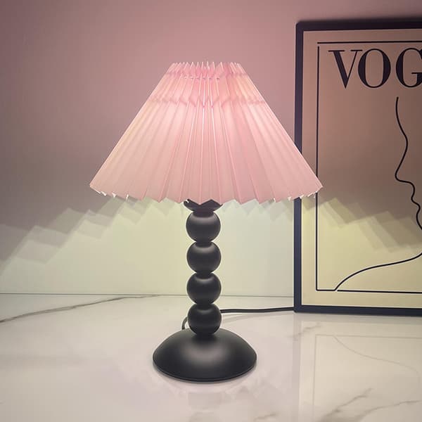 Bordlampe med lyserød plisseret lampeskærm og perleformet fod