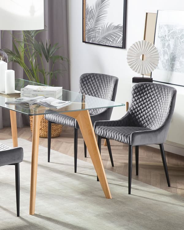 Et sæt med 2 grå velourpolstrede stole med sorte metalben til en spisestue i retro glamourstil