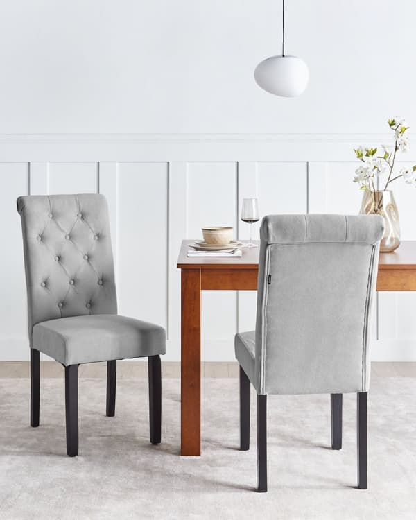 Sæt med 2 grå polstrede stole med sorte træben til en spisestue i glam stil