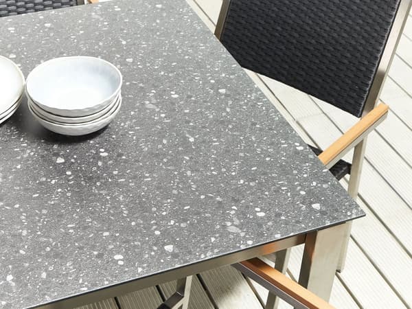 Hagespisesett Svart bordplate i granitteffekt Glassramme i rustfritt stål Sett med 6 stoler PE-rottingseter Moderne utendørsstil