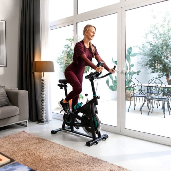 Cecotec Indoor bike with 10-kg flywheel, hand resistance, LCD console, device holder, bottle, and bottle holder.