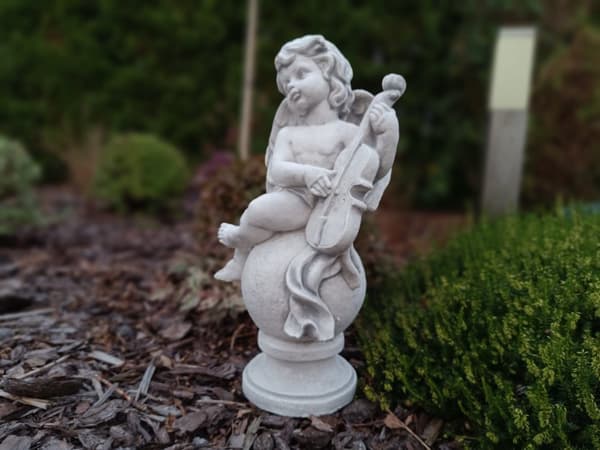 Klassisk sittande kerub med musikinstrument i arkitektonisk betong