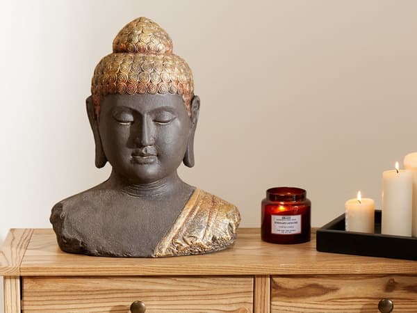Dekorativ figur i sort og guld med buddha-dekoration i ældet finish til indendørs brug