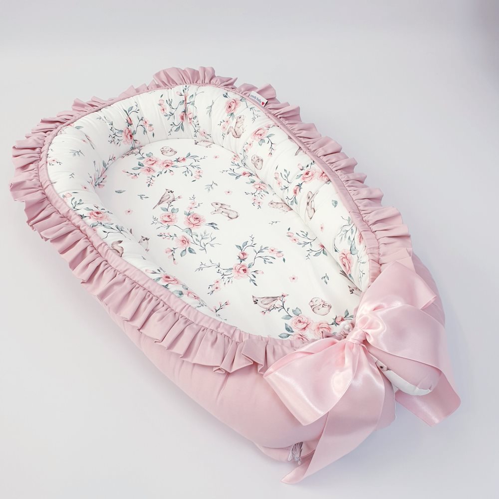 Babynest med blommotiv och puderrosa volang