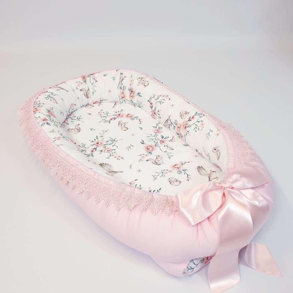 Babynest med blommotiv och rosa spets
