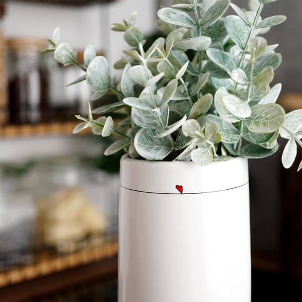 Vit keramikvas med subtilt hjärtmotiv för blommor