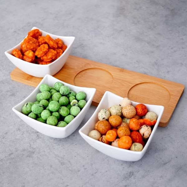 Tre elegante porcelænsskåle på bambusbakke til snacks og dips