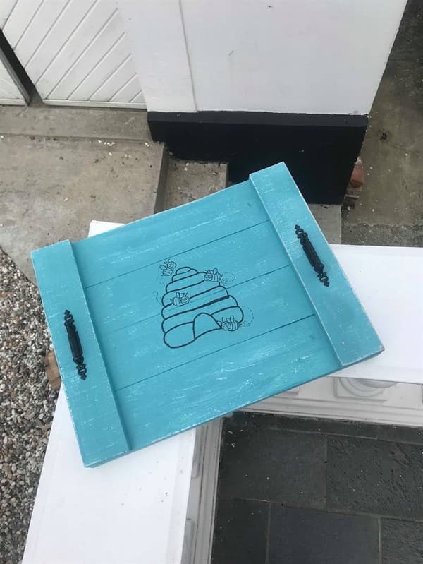 Bakke i tyrkis med bikube og bier