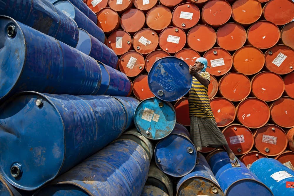 Worker Sorting Colorful Oil Drums Poster