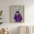Pikkukuva 6 / 11: Julistelaama violetissa hupparissa kameralla Julistelaama purppuranpunaisessa hupparissa kameralla, 40x50 cm, kehyksetön, 230 gsm mattapaperi