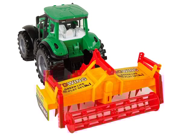 Grön traktor med orange kultivatordrift för barn