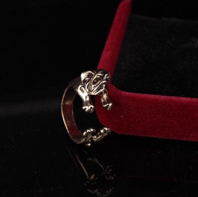 Ring til en mops hund, der krammer fingeren