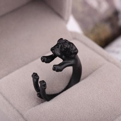 Ring til en mops hund, der krammer fingeren