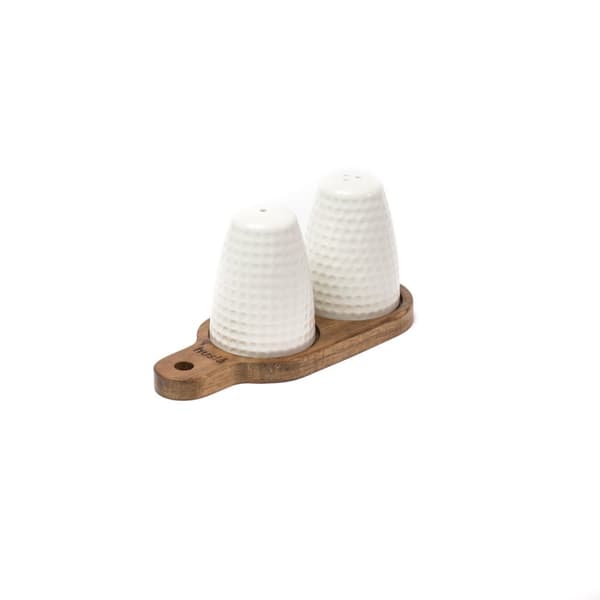 Et sæt salt og peber shakers på et akaciebræt