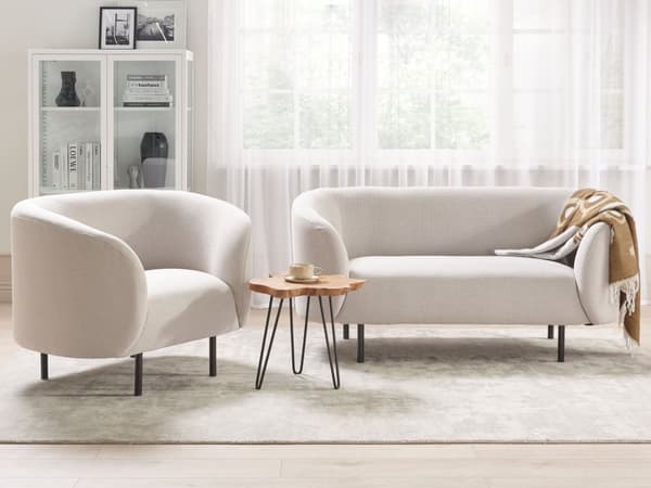 Sohva beige kangas verhoiltu mustat rautajalat kahdelle kaareva perinteinen glamour tyyli