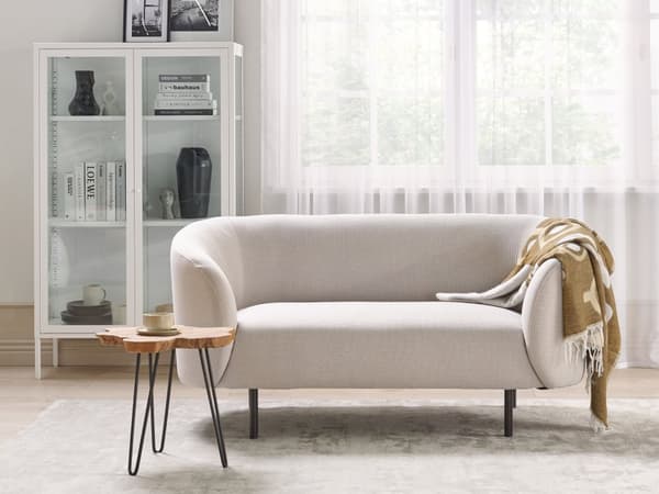 Sohva beige kangas verhoiltu mustat rautajalat kahdelle kaareva perinteinen glamour tyyli