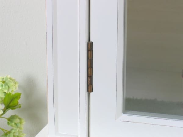 Amaretta vitrinskåp 3 dörrar antik vit, antik patinerat. Bredd 142 cm, höjd 200 cm.