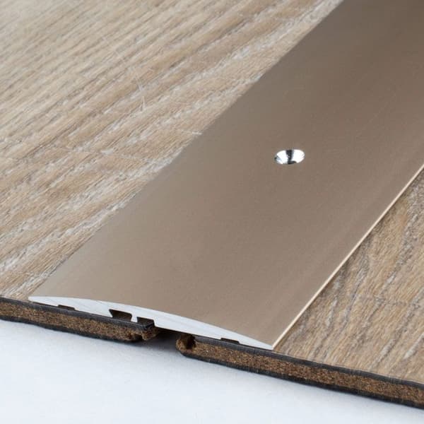 Tröskelbar i anodiserad aluminium bronsljus L 58 mm H 4 mm Lång 2700 mm Genomgående hål
