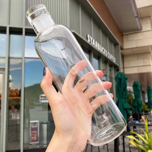 Lasillinen vesipullo, jonka ajan merkitsee 500 ml läpikuultavaa