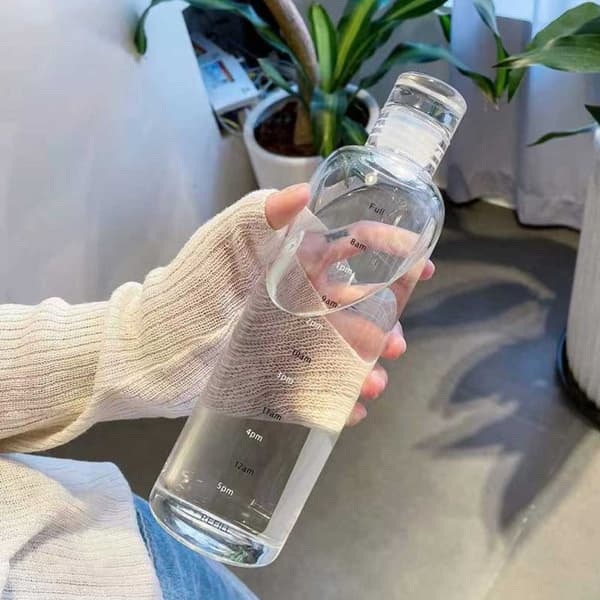 Lasillinen vesipullo, jonka ajan merkitsee 500 ml läpikuultavaa