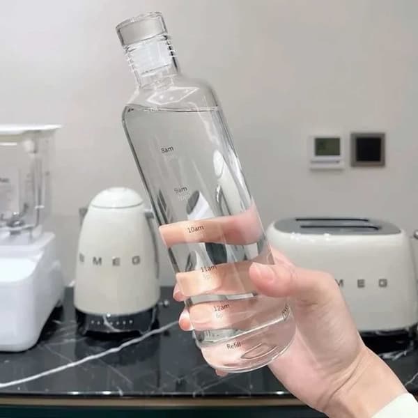 Lasillinen vesipullo, jonka ajan merkitsee 500 ml läpikuultavaa