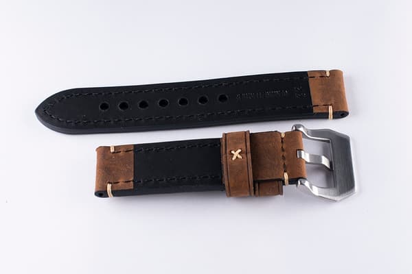 Brunt kraftigt klockarmband av läder med sömmar